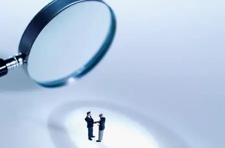 Magnifying glass focused on two professional men
